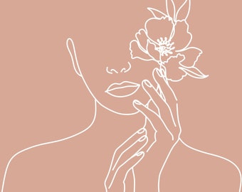 May include: Line art illustration of a woman's face with a flower behind her ear. The background is a light pink color. The text "If you need a specific design please message me before placing an order." is at the bottom of the image.