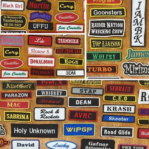 以下が含まれることがあります： 様々な形と色をした刺繍パッチのコレクション。名前、フレーズ、ロゴが特徴です。「Black Girl」、「Whiskey」、「Road Glide」などのテキストが含まれており、フォントとデザインが混在しています。これらのパッチは、おそらく衣類やアクセサリー用です。