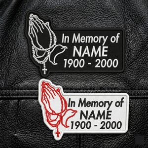 May include: Two rectangular embroidered patches featuring praying hands holding a rosary. One patch is black with white text and embroidery, the other is white with black text and red embroidery. Both read In Memory of NAME 1900 - 2000.