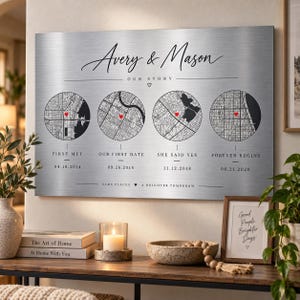 May include: A rectangular brushed metal wall plaque titled Avery & Mason Our Story featuring four circular black and white city map illustrations with red heart markers, accompanied by significant dates labeled First Met, Our First Date, She Said Yes, and Forever Begins.