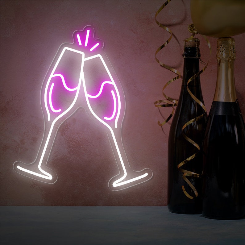 May include: Two pink neon champagne glasses clinking together, with a white outline, against a pink wall.