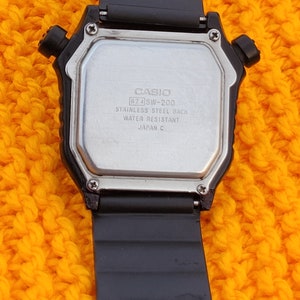 Puede incluir: Reloj digital Casio negro con fondo de acero inoxidable. El reloj es resistente al agua y est&aacute; hecho en Jap&oacute;n. El reloj tiene una correa negra con un dise&ntilde;o texturizado.