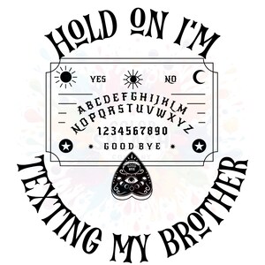 May include: Black and white Ouija board design with the text "HOLD ON I'M TEXTING MY BROTHER". The board includes the alphabet, numbers, and the words "YES", "NO", and "GOOD BYE". A planchette is also included.
