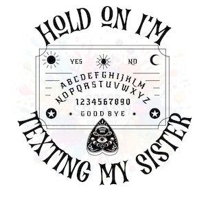 May include: A white Ouija board design with the text "HOLD ON I'M TEXTING MY SISTER" in a circular arrangement. The board includes the alphabet, numbers, and the words "YES", "NO", and "GOOD BYE". A planchette is at the bottom.