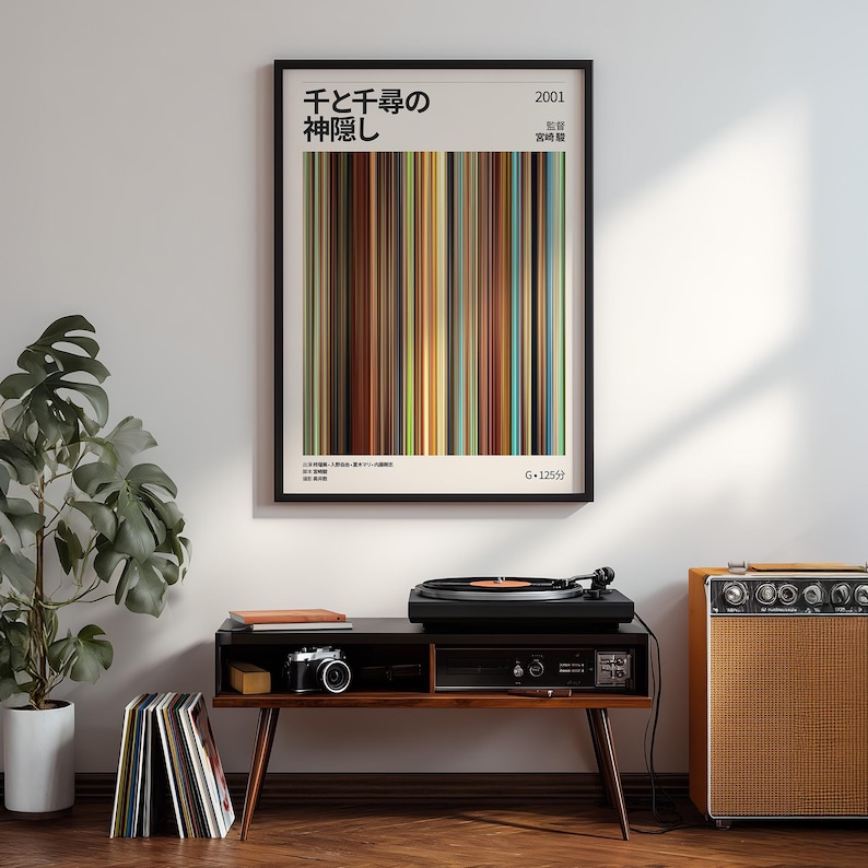 May include: A framed poster with Japanese text and vertical color bars hangs on a white wall. Below, a record player sits on a dark wood console with a camera and records. An orange amplifier is to the right.