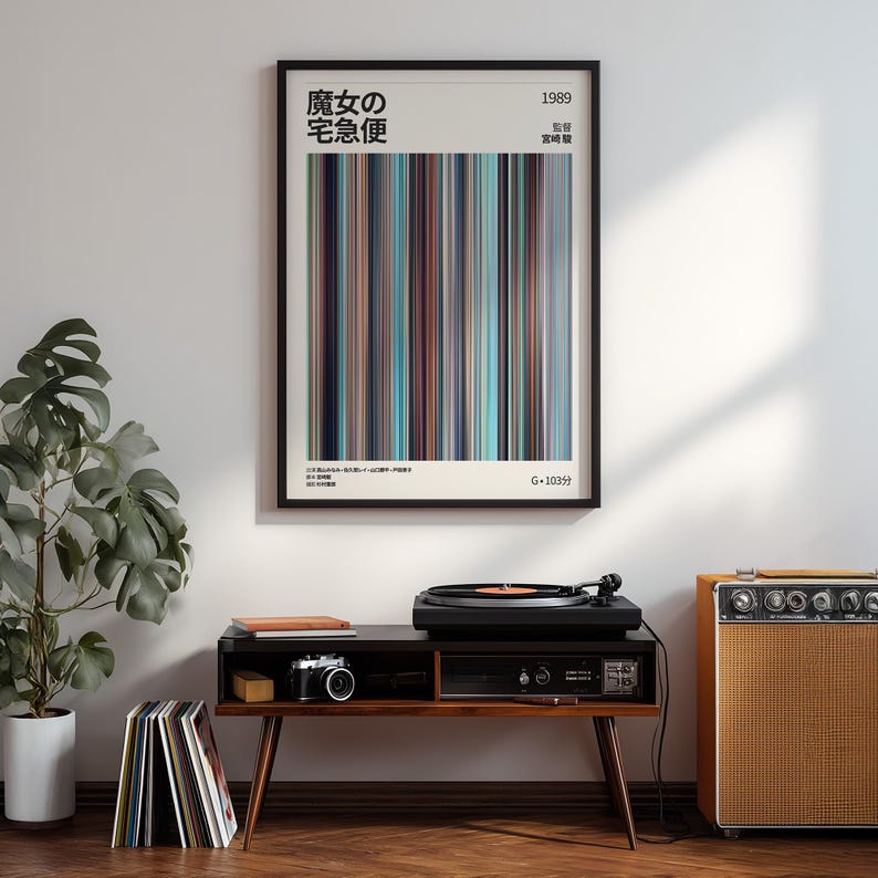 May include: A framed poster with Japanese text and vertical stripes in shades of brown, blue, and teal. The poster is above a mid-century modern style record player console with a turntable, camera, and amplifier.