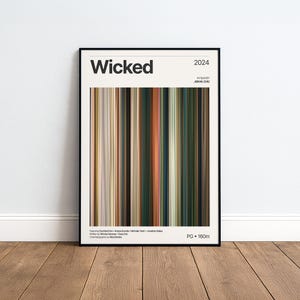 Könnte beinhalten: Ein gerahmtes Filmplakat für den Film Wicked aus dem Jahr 2024 mit einer zentralen vertikalen Farbpalette aus Streifen in Grün-, Braun- und Goldtönen. Der Text enthält den Titel Wicked, das Jahr 2024, Regisseur Jon M. Chu, Besetzungsnamen und PG 160m.