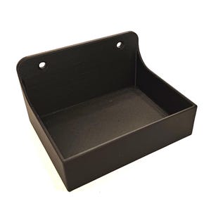 Puede incluir: Un contenedor de almacenamiento de plástico negro de pared con dos agujeros en la parte superior para colgar.