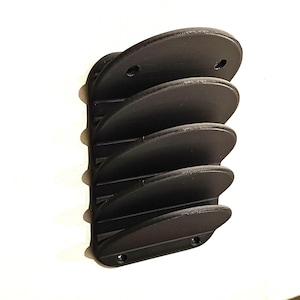 Può includere: Organizzatore da parete nero con cinque fessure curve per riporre oggetti come CD o DVD.
