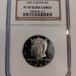 Peut inclure: Une pièce de monnaie en argent 2002 S 50C dans un étui de protection. La pièce présente un profil d'une personne et le texte "IN GOD WE TRUST". L'étui porte l'inscription "PF 70 ULTRA CAMEO" et "NUMISMATIC GUARANTY CORPORATION".