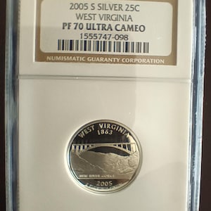 Peut inclure: Une pièce de monnaie de 25 cents de la Virginie-Occidentale de 2005, classée PF 70 Ultra Cameo, dans un boîtier de protection. La pièce représente le pont de New River Gorge et le texte "West Virginia 1863". Le boîtier comprend le texte "2005 S SILVER 25C" et "NUMISMATIC GUARANTY CORPORATION".
