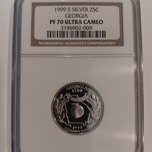 Peut inclure: Une pièce de monnaie de 25C en argent de Géorgie de 1999 S, classée PF 70 Ultra Cameo, dans un boîtier de protection. La pièce présente un motif de pêche avec les inscriptions "Georgia 1788", "Justice" et "E Pluribus Unum". Le boîtier contient une étiquette avec des informations de classement.