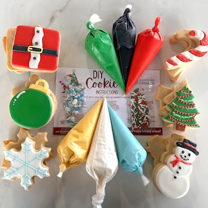 以下が含まれることがあります： クリスマスをテーマにしたクッキーのデコレーションキット。雪だるま、クリスマスツリー、キャンディーケーン、雪の結晶、サンタクロース、オーナメントなど、さまざまなクッキーが入っています。キットには、さまざまな色のアイシングが5袋、スプリンクル、説明書が含まれています。