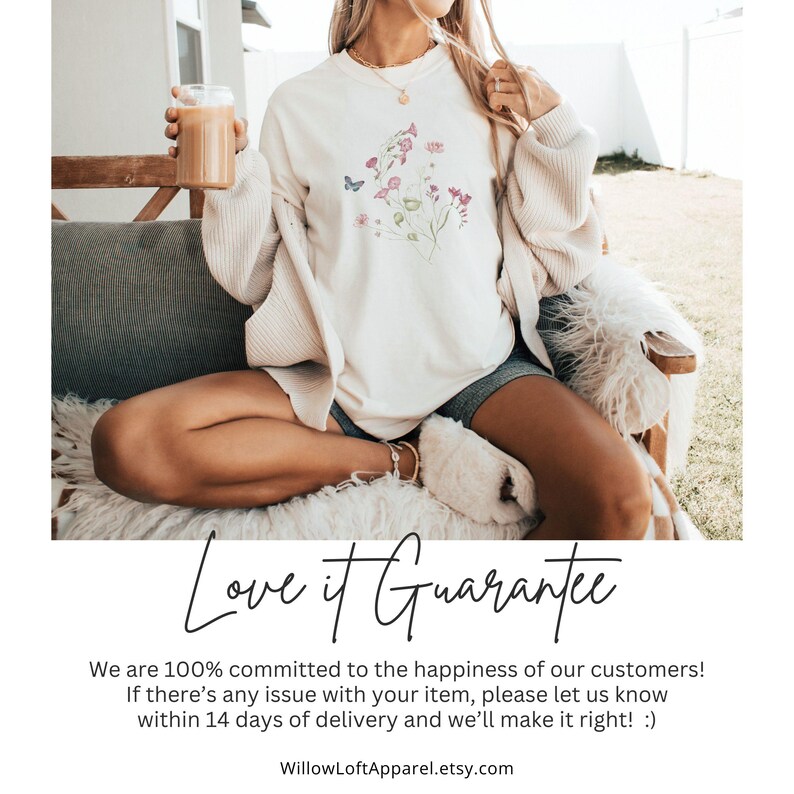 May include: Cream-colored sweatshirt with a floral design and a butterfly. The text "Love it Guarantee" is displayed below the image. The model is wearing shorts and a cardigan, holding a glass of a beverage.