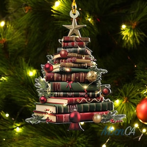 May include: A Christmas tree ornament shaped like a stack of books with a star on top. The books are decorated with red and gold ornaments and a string of lights.