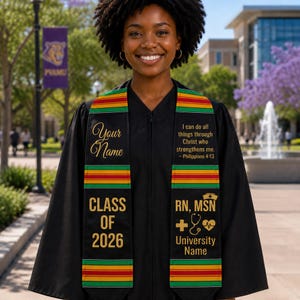 May include: A black graduation stole featuring horizontal red, yellow, and green stripes. The left side displays "Your Name" and "CLASS OF 2026". The right side features "I can do all things through Christ who strengthens me. - Philippians 4:13", "RN, MSN", and icons of a nurse cap, cross, stethoscope, and heart.