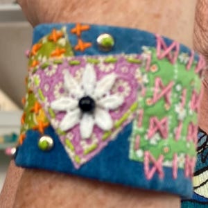 May include: A white ceramic mug with a black handle and the text "But First, Coffee" in a black, handwritten-style font. The mug is on a white surface.