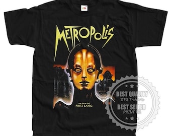 May include: Black t-shirt with a graphic print of a woman's face from the movie "Metropolis". The text "Metropolis", "Un film de Fritz Lang" and "Best Quality DTG T-shirts Best Seller Print KR" are printed on the shirt.