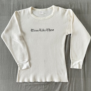 Könnte beinhalten: Weißes, langärmliges Waffel-Thermo-Shirt mit schwarzem Sticktext "Times Like These".