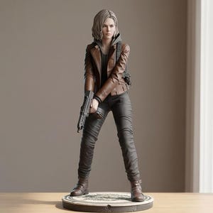 May include: A detailed figurine of a woman in a brown leather jacket, gray hoodie, and dark trousers, holding a gun. The figure stands on a round base with a detailed design. The overall colour palette is muted with brown, grey, and black tones.
