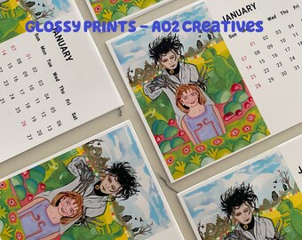 May include: A set of four glossy print calendars featuring a whimsical illustration of two figures in a garden setting. The calendar is for January and features the text "GLOSSY PRINTS - A02 CREATIVES".