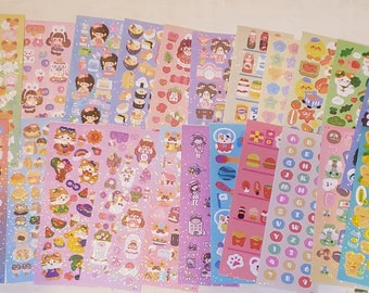 May include: A set of 18 sheets of colorful stickers featuring various designs, including cartoon animals, food, letters, and numbers. The stickers are printed on a glossy, glittery paper.