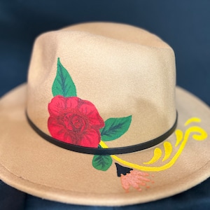 Custom hand painted red rose on a brown felt fedora with yellow, green, and orange accents, under rim is red; one size fits most