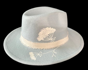 Custom hand painted light blue felt fedora with natural boho white floral accents. Adjustable inner strap, one size fits most.