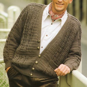May include: A brown knitted cardigan with a cable knit pattern, featuring a V-neck, button closure, and two patch pockets.