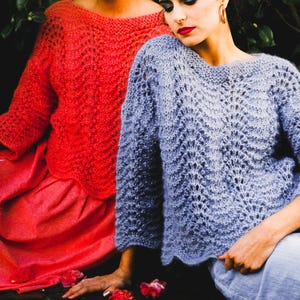May include: A long-sleeved sweater featuring an openwork wave pattern and a wide neckline. One sweater is vibrant coral, and the other is a soft periwinkle blue. Both garments are crafted with a loose, airy knit texture and have scalloped edges.