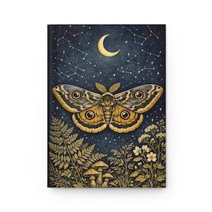 May include: A hardcover journal featuring a dark blue night sky with a crescent moon and constellations. A large moth with golden-brown and black patterned wings is centered above a forest floor with ferns, small mushrooms, and wildflowers.