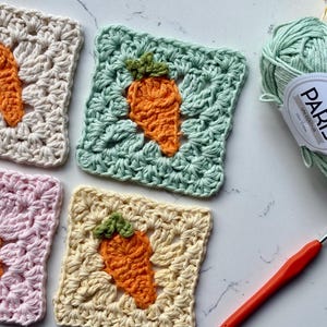 May include: A trio of cream-glazed ceramic mugs, each adorned with a hand-painted floral pattern in blue, green, and yellow. The mugs have a speckled finish and a classic, rounded design with a handle.