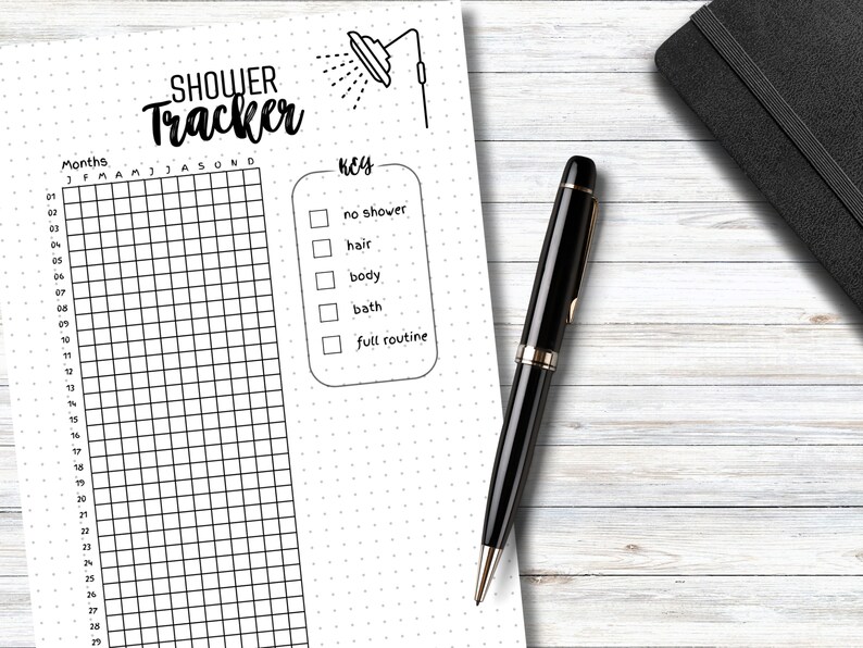 May include: A black and white printable shower tracker with a shower icon at the top. The tracker has a grid with 28 rows and 12 columns. The columns are labelled with the months of the year. The rows are numbered from 1 to 28. There is a key to the right of the grid with checkboxes for "no shower", "hair", "body", "bath", and "full routine".