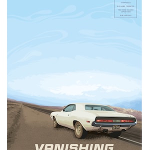 May include: A white 1970s Dodge Challenger muscle car driving down a desert road with a blue sky in the background. The car has a black license plate with the letters OA and the numbers 5599. The car is driving towards the viewer.