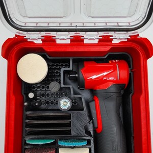 May include: A red and black power tool kit with a clear lid. The kit contains a red power tool with the word "FUEL" and a white lightning bolt logo. The kit also includes various attachments and polishing pads.