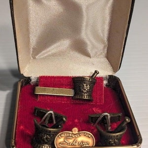 Puede incluir: Un juego de tres tazas de cerámica con un acabado moteado y mate. Las tazas son de color crema, gris claro y gris oscuro. Cada taza tiene un diseño simple y minimalista.