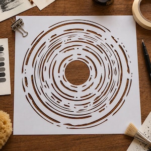 May include: A square white stencil featuring a central circular cutout surrounded by concentric, irregular, organic ring patterns. The design consists of thin, broken lines and varied gaps that create a textured, tree-ring-like appearance.
