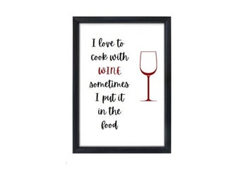 May include: Black framed print with a white background and black text that reads "I love to cook with wine sometimes I put it in the food". A red wine glass is to the right of the text.