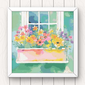 May include: A window box overflowing with colorful flowers in shades of pink, yellow, and purple. The window box is painted a light pink with white trim and sits on a green windowsill.
