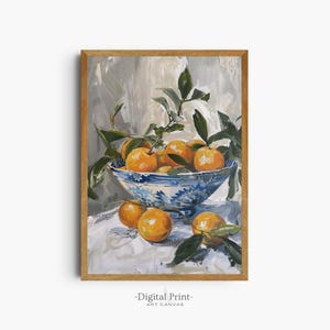 Op de afbeelding: Een schilderij van een kom vol sinaasappelen en groene bladeren. De kom is blauw en wit met een bloemenpatroon. De sinaasappelen zijn in een stillevencompositie op een wit tafelkleed gerangschikt.
