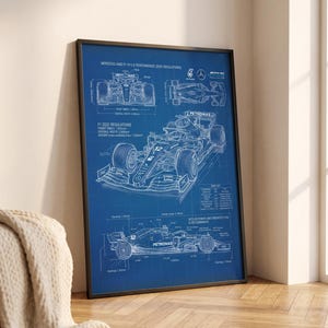 Peut inclure: Une affiche de plan encadrée présentant des dessins techniques au trait de la voiture de course Mercedes-AMG F1 W13 E Performance. Le design comprend des vues de face, de dessus et de côté avec des annotations détaillées, des spécifications techniques et des étiquettes en blanc sur fond bleu.