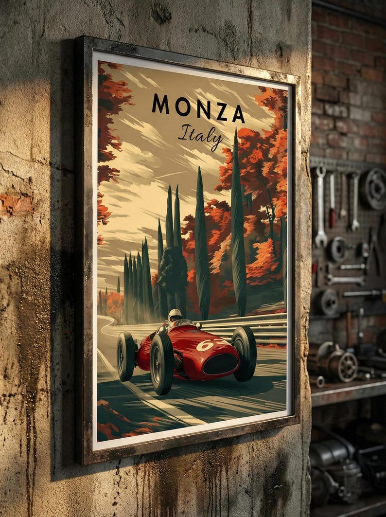 May include: Framed vintage poster of a red race car speeding on a track in Monza, Italy. The poster features the text "MONZA Italy" at the top, with a scenic backdrop of trees and a cloudy sky. The poster is displayed on a textured wall.
