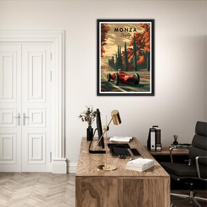 May include: Framed art print featuring a vintage race car speeding along a track, with the text "MONZA Italy" at the top. The artwork has a retro style with a color palette of red, green, and brown. The print is displayed in a black frame.