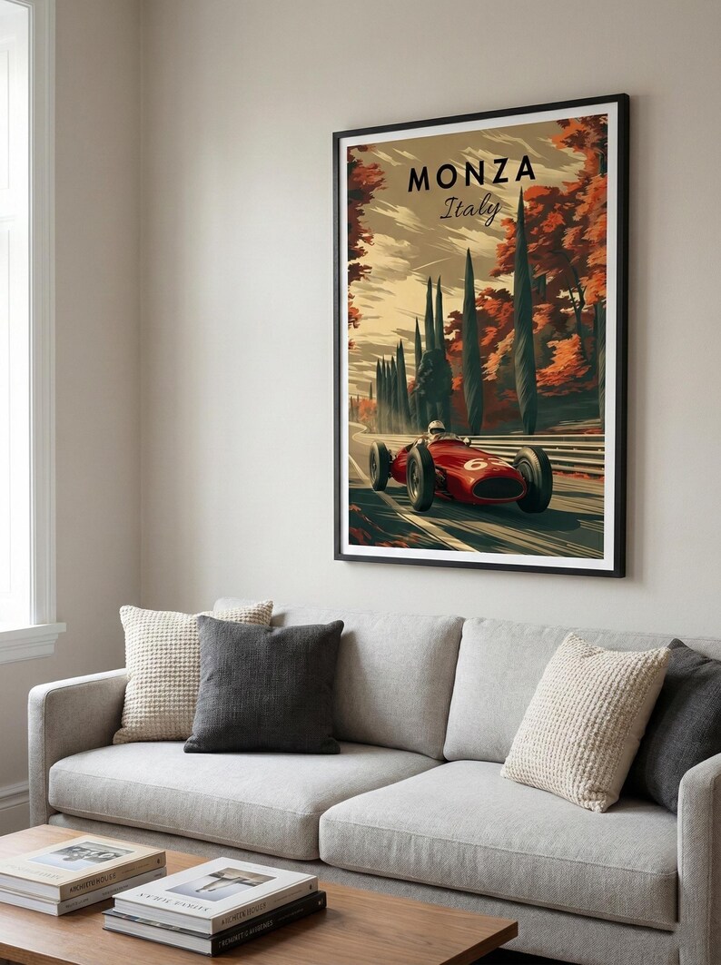 May include: A framed art print featuring a vintage race car speeding on a track. The artwork, titled "Monza Italy," showcases a red race car against a backdrop of autumn trees. The print is displayed above a gray sofa with decorative pillows.
