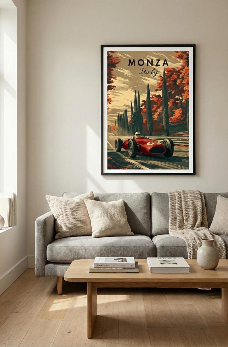 May include: A framed art print featuring a vintage race car speeding along a tree-lined road in Monza, Italy. The artwork has a retro style with a red race car and the text "MONZA Italy". The print is displayed above a gray sofa.