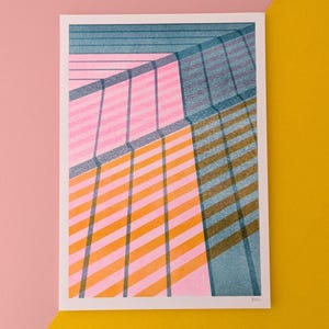 May include: A rectangular art print featuring a geometric composition of overlapping diagonal stripes in shades of pink, orange, and teal blue. The design creates a layered, translucent effect with intersecting lines and blocks of colour on a white background.
