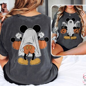 Puede incluir: Una camiseta gris oscuro jaspeada con un gr&aacute;fico de estilo vintage de Mickey Mouse vestido de fantasma sosteniendo calabazas. El gr&aacute;fico est&aacute; impreso en la parte posterior de la camiseta.