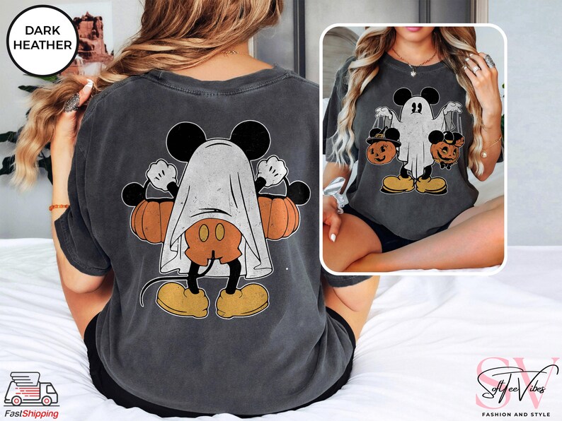 Puede incluir: Una camiseta gris oscuro jaspeada con un gr&aacute;fico de estilo vintage de Mickey Mouse vestido de fantasma sosteniendo calabazas. El gr&aacute;fico est&aacute; impreso en la parte posterior de la camiseta.