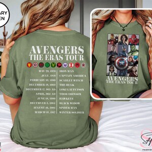 Może przedstawiać: Zielona koszulka z grafiką postaci Avengers&oacute;w i tekstem "Avengers The Eras Tour". Grafika zawiera Iron Mana, Kapitana Amerykę, Szkarłatną Wiedźmę, Hulka, Thora Odyna, Lokiego Laufeysona, Sokoła, Czarną Wdowę, Spider-Mana i Zimowego Żołnierza. Daty ich pierwszych pojawień się są wymienione pod każdym bohaterem.