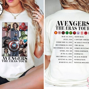 Może przedstawiać: Biały T-shirt z kolażem postaci Avengers, w tym Iron Man, Kapitan Ameryka, Thor, Hulk i Czarna Wdowa. Na plecach koszulki wymieniono postacie Avengers i ich pierwsze występy w Marvel Cinematic Universe.